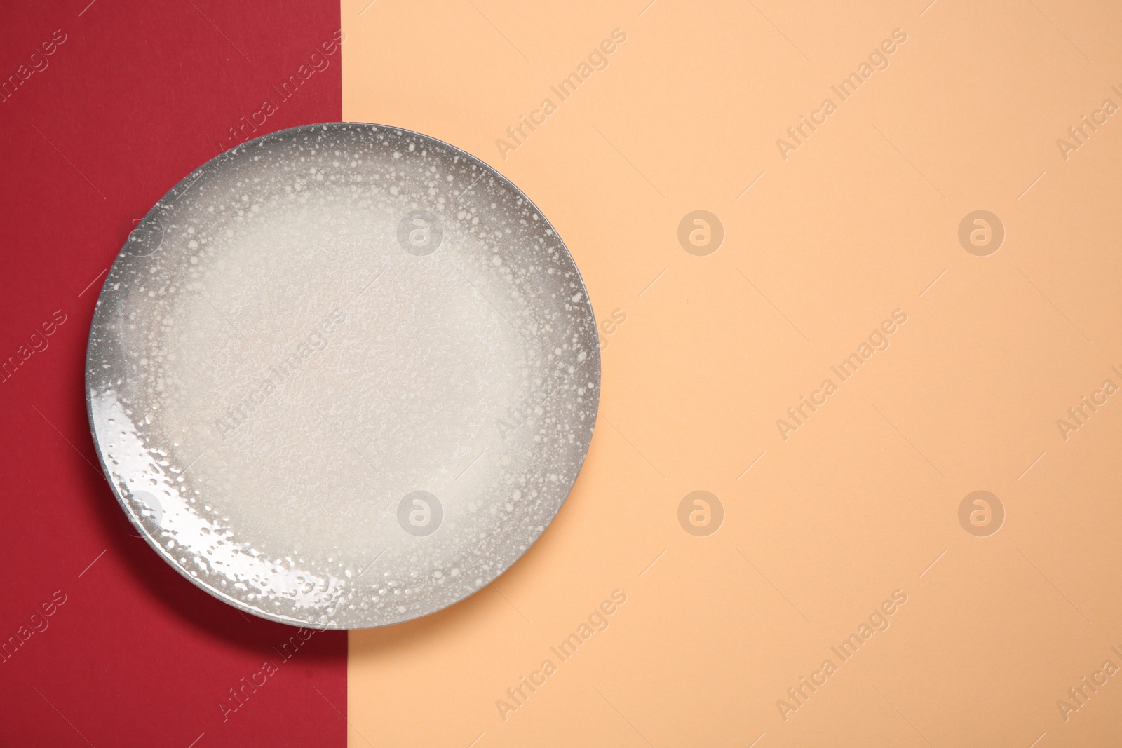 Photo of One ceramic plate on color background, top view. Space for text