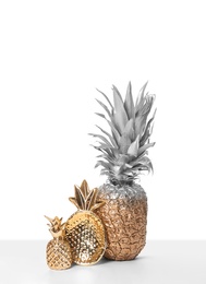Photo of Silver and gold painted pineapple with cute decor on white background