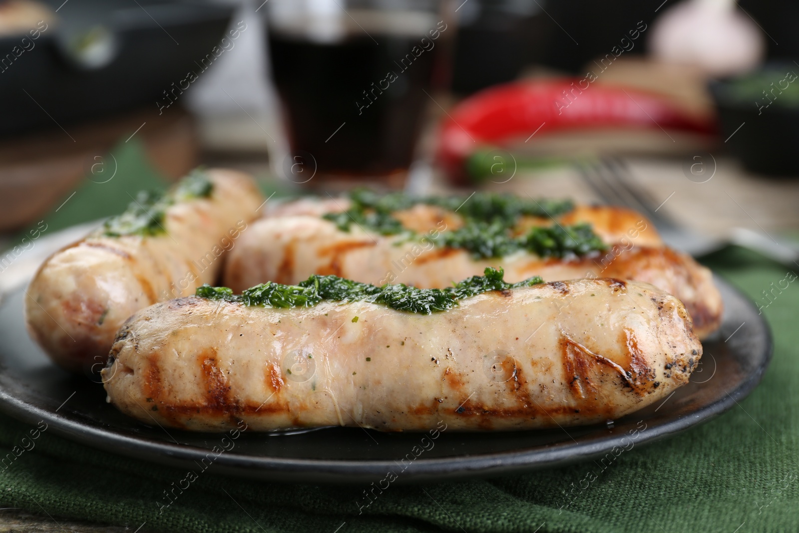 Photo of Tasty fresh grilled sausages with sauce on table, closeup