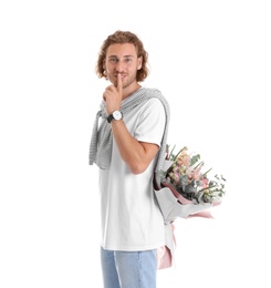 Photo of Young handsome man hiding beautiful flower bouquet behind his back on white background