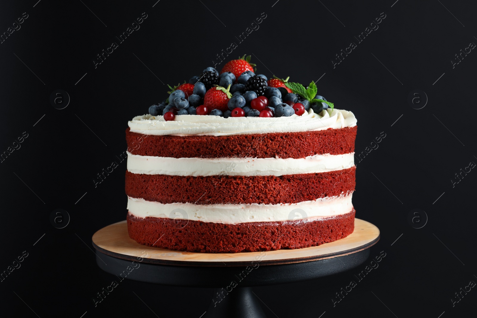 Photo of Stand with delicious homemade red velvet cake on black background