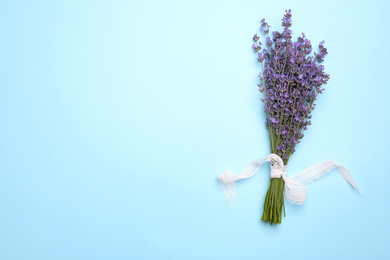 Beautiful lavender bouquet on light blue background, top view. Space for text