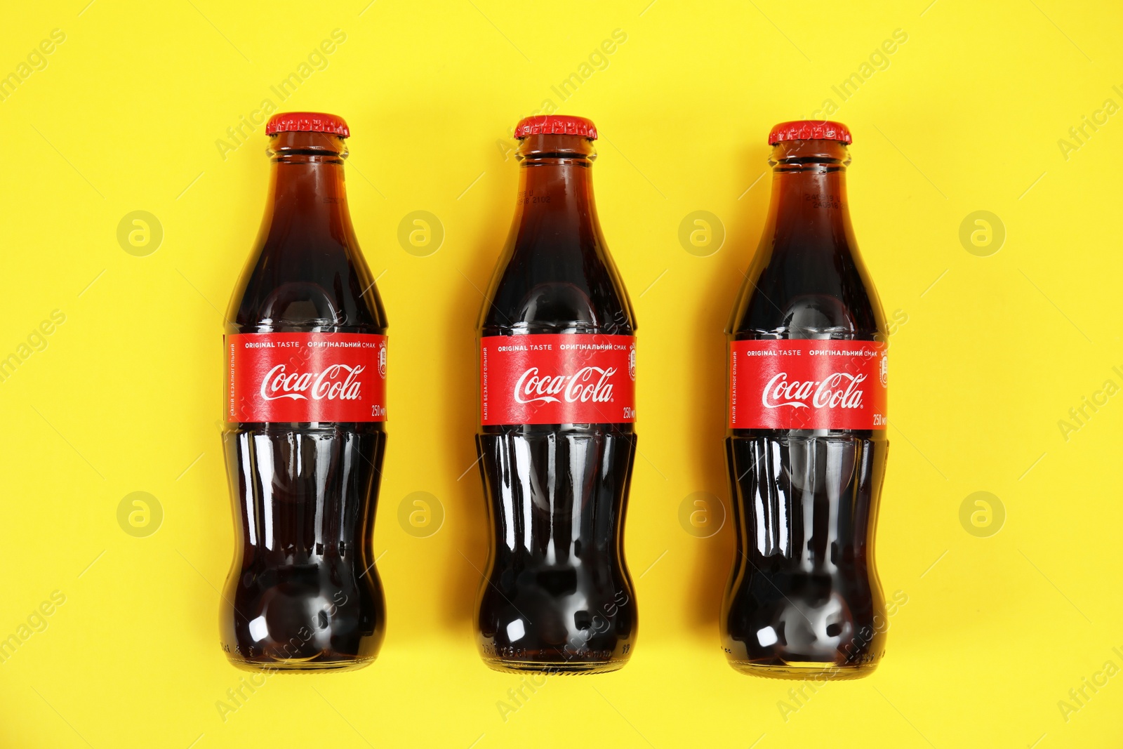 Photo of MYKOLAIV, UKRAINE - NOVEMBER 14, 2018: Bottles of Coca-Cola on color background, top view