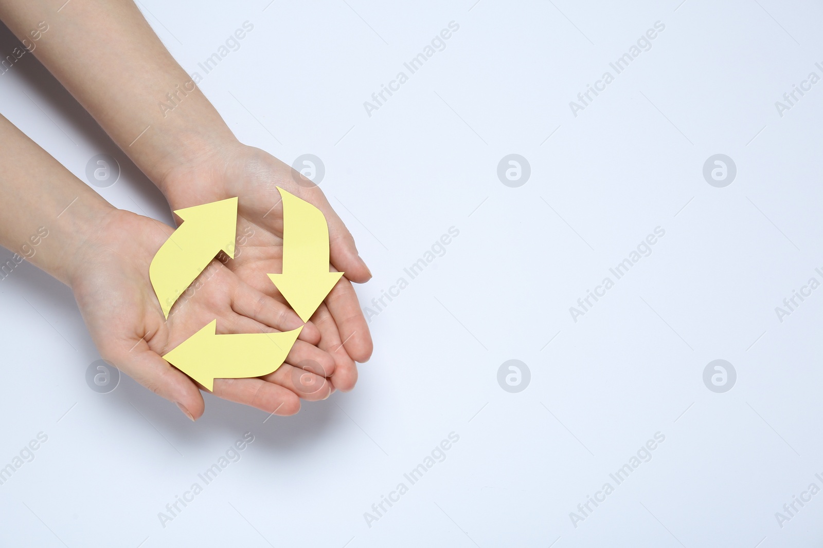 Photo of Woman holding Recycling symbol made of paper on white background, top view. Space for text