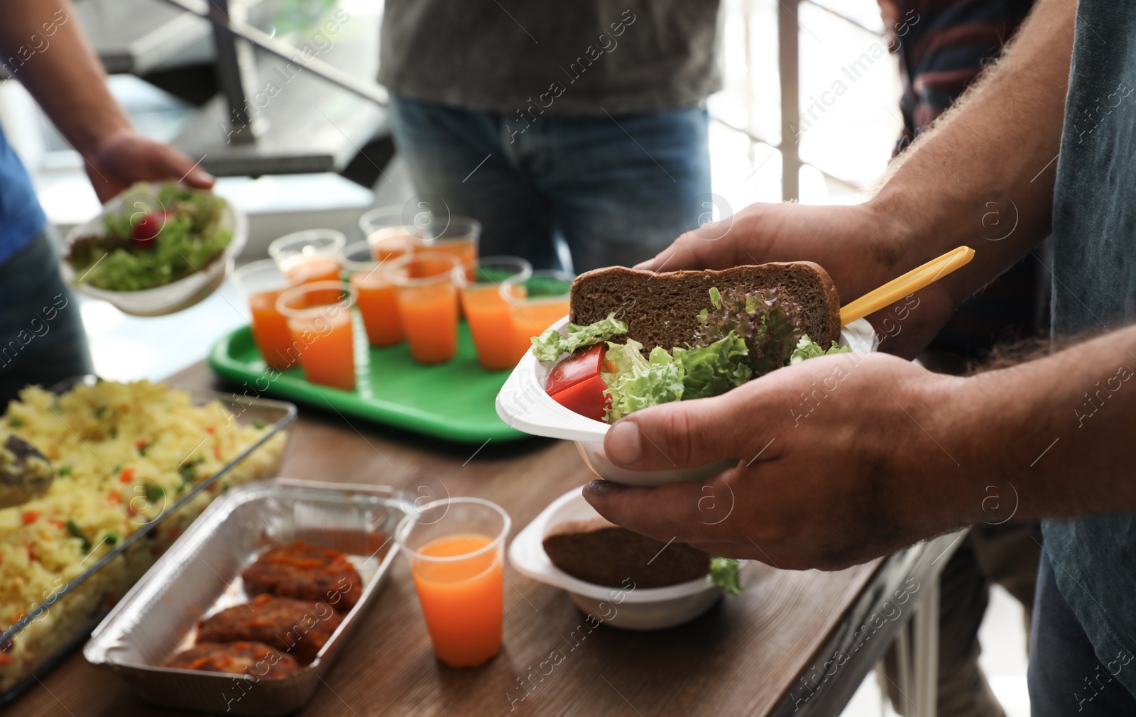 Photo of Poor man holding plate with food in charity centre