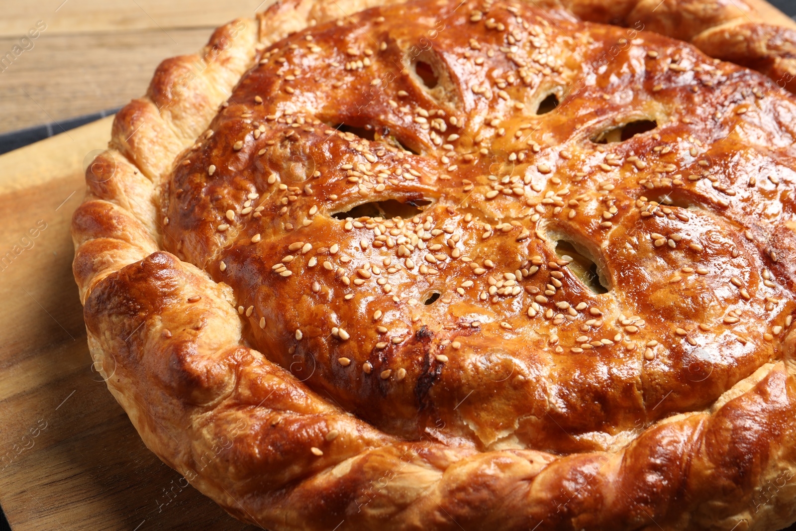 Photo of Tasty homemade pie with filling on wooden table, closeup