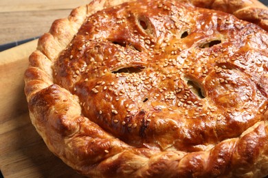 Tasty homemade pie with filling on wooden table, closeup