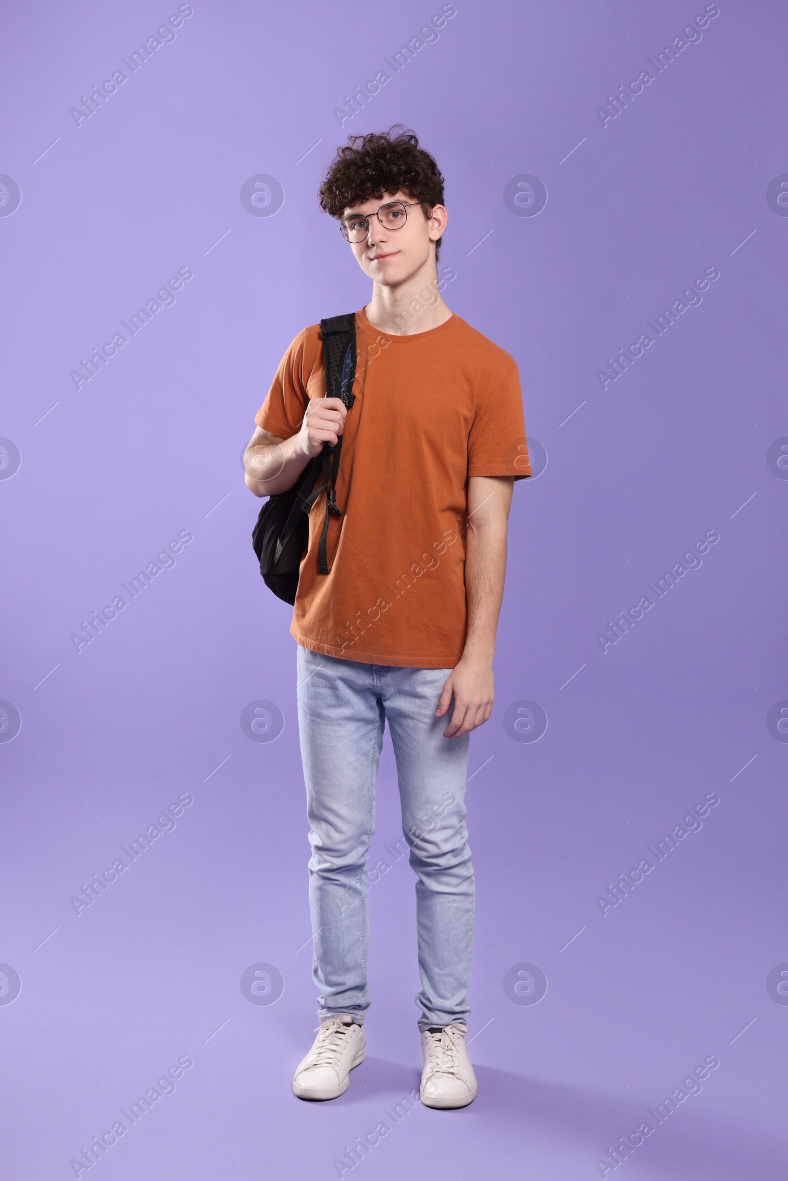 Photo of Cute teenage boy wearing glasses on violet background