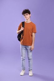 Cute teenage boy wearing glasses on violet background