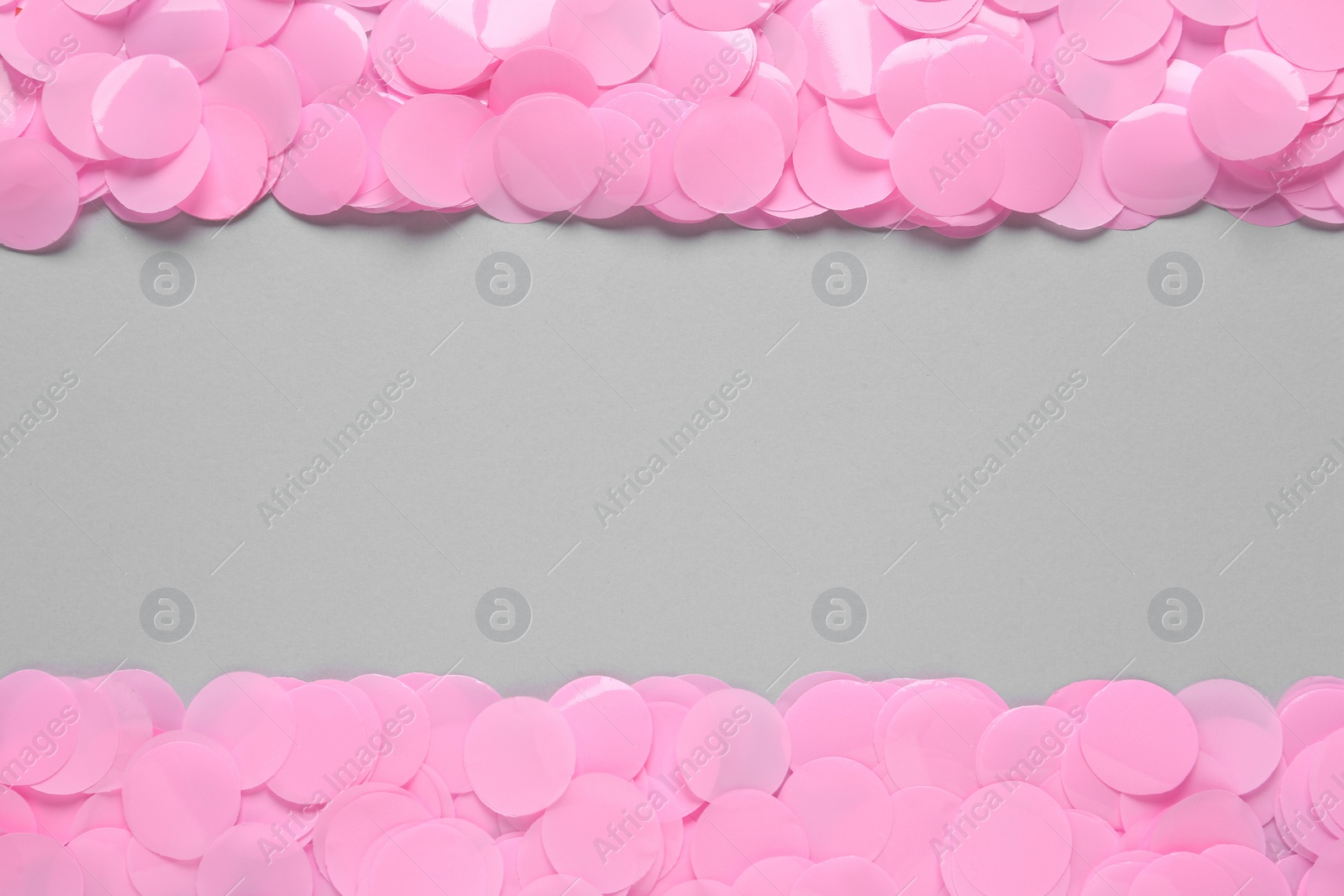 Photo of Pink confetti on light grey background, flat lay. Space for text