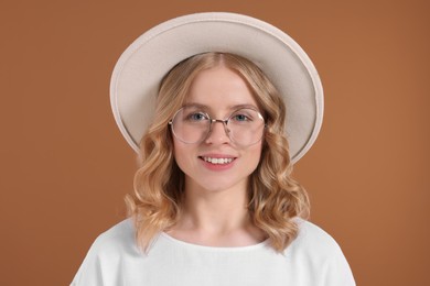 Photo of Beautiful woman with blonde hair in hat on brown background