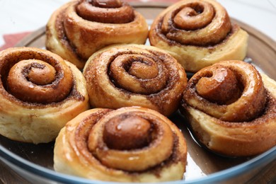 Tasty cinnamon rolls on in baking dish table, closeup