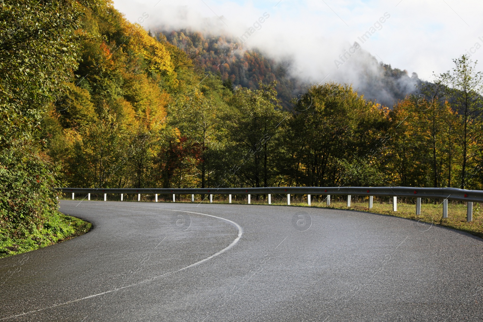 Photo of Picturesque view of empty road near trees in mountains