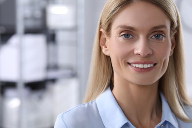 Portrait of beautiful woman in formal clothes indoors. Space for text. Confident lady with blonde hair looking into camera