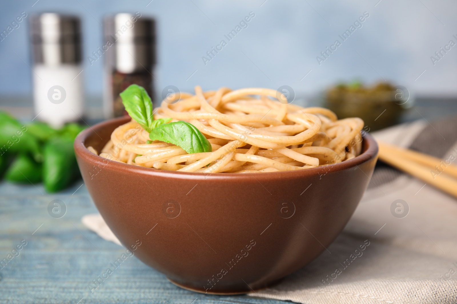 Photo of Tasty buckwheat noodles served on blue wooden table