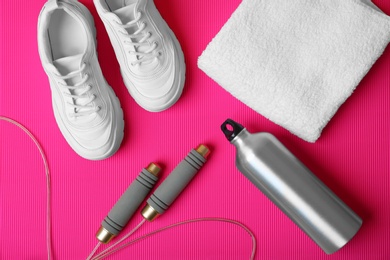 Photo of Flat lay composition with fitness equipment on color background