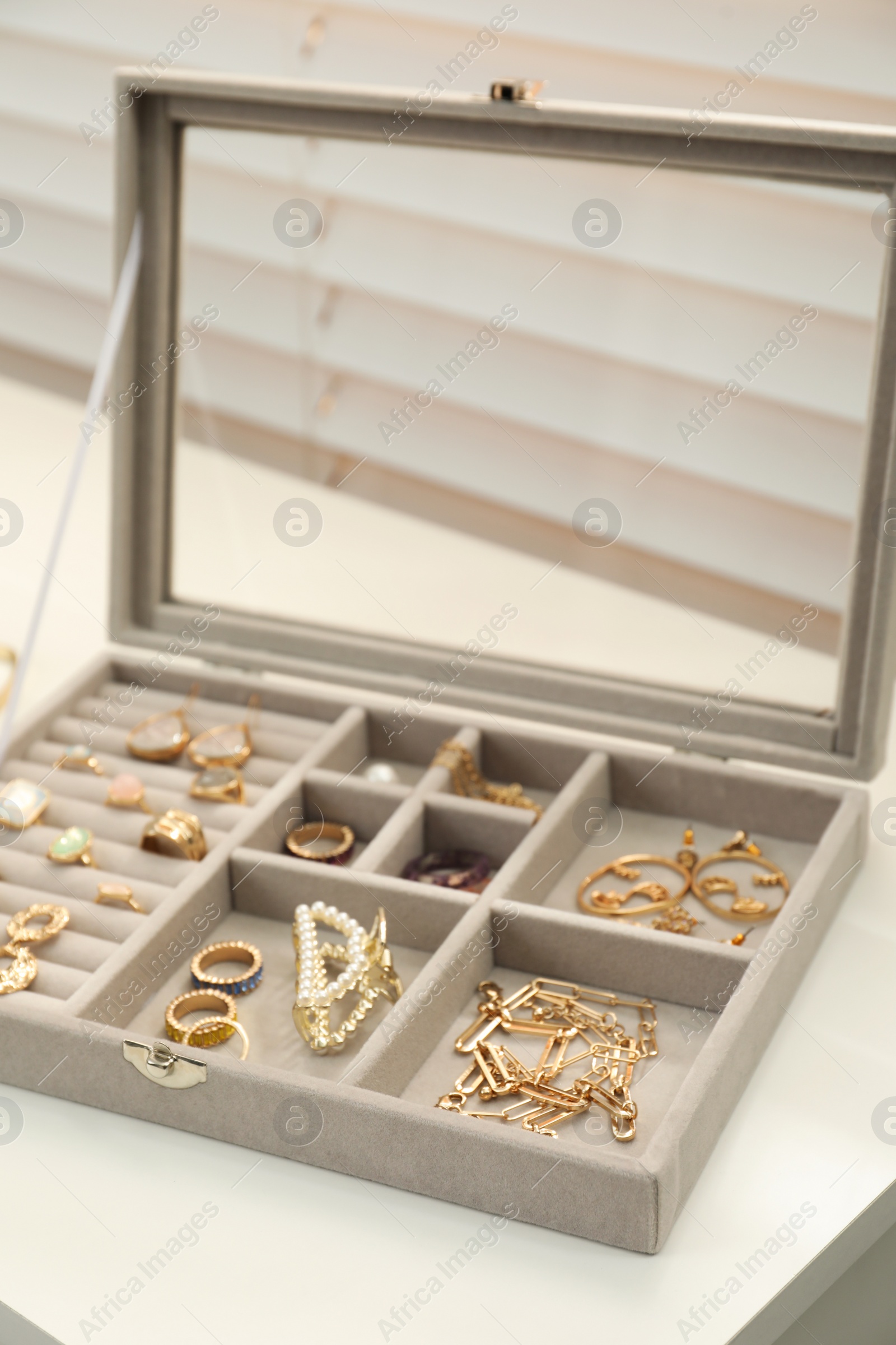 Photo of Elegant jewelry box with beautiful bijouterie on white table indoors