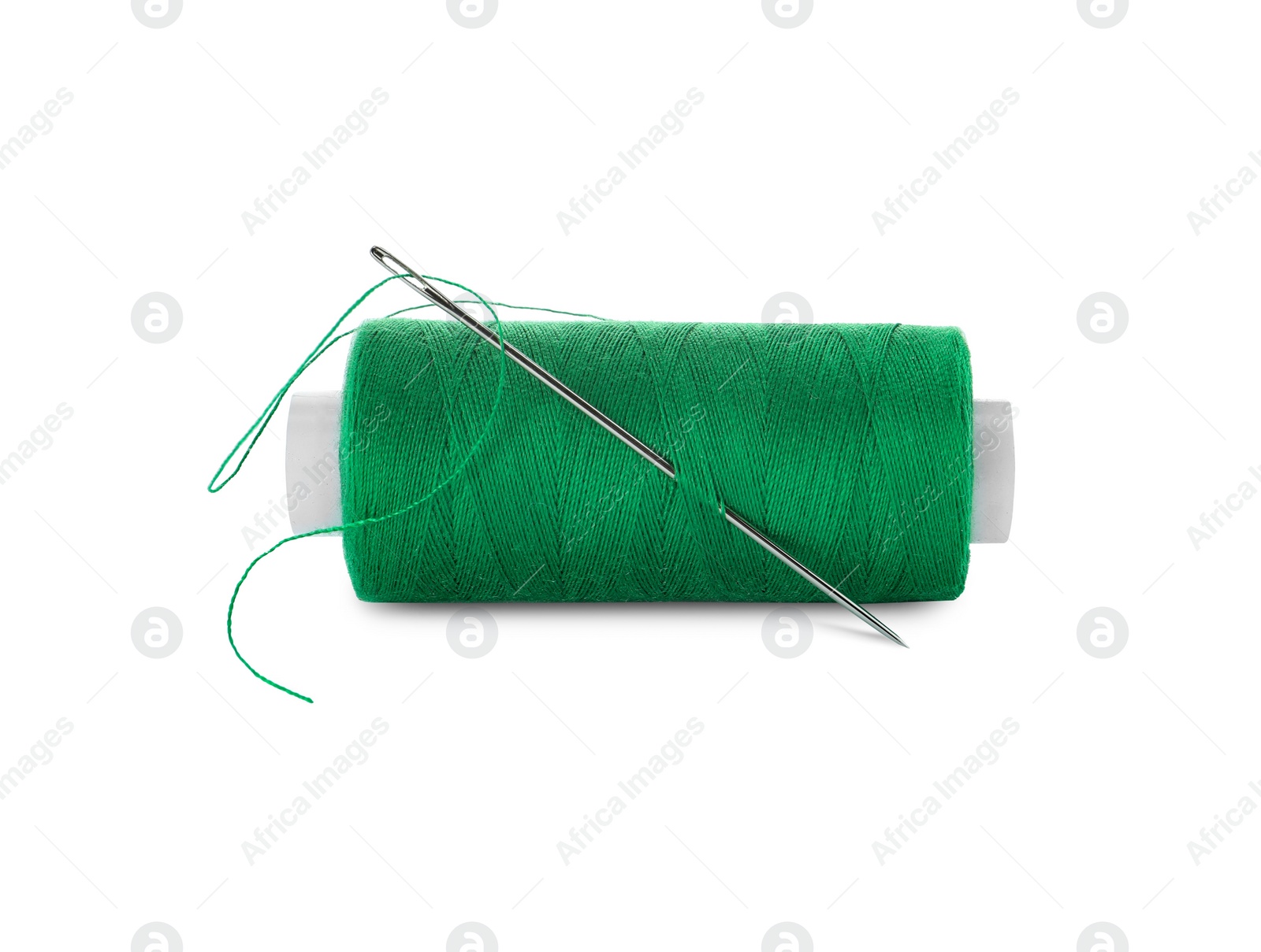 Photo of Spool of green sewing thread with needle isolated on white