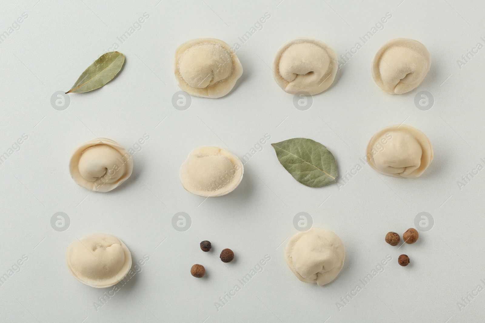 Photo of Composition with dumplings, bay leaves and pepper on white background, top view