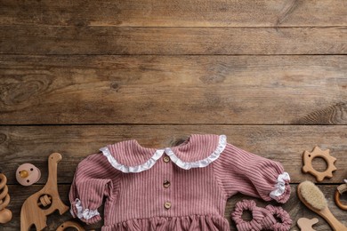 Photo of Flat lay composition with baby clothes and accessories on wooden background, space for text