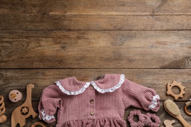 Flat lay composition with baby clothes and accessories on wooden background, space for text