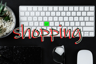 Image of Flat lay composition of modern computer keyboard with cart symbol on black table. Internet shopping