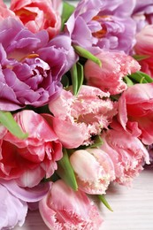 Photo of Beautiful bouquet of colorful tulip flowers on white table, closeup