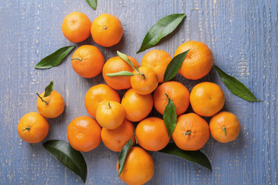 Photo of Fresh ripe tangerines on grey wooden table, flat lay