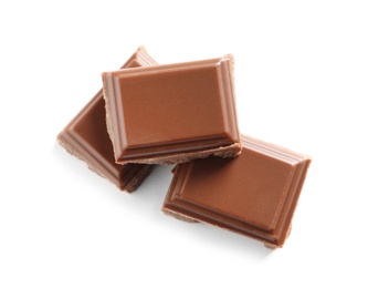 Pieces of tasty milk chocolate on white background, top view