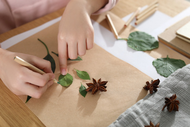 Photo of Little girl working with natural materials at table, closeup. Creative hobby
