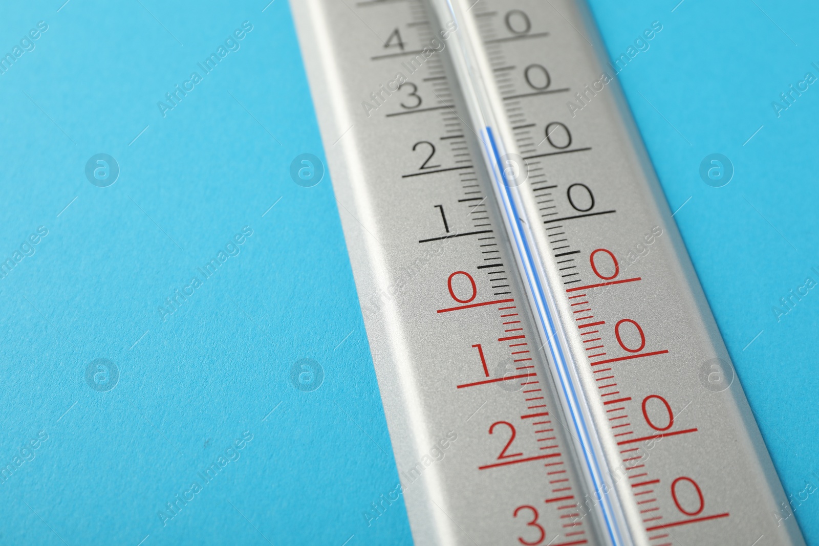 Photo of Weather thermometer on light blue background, closeup. Space for text