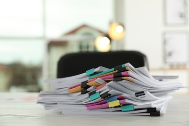 Photo of Stack of documents with paper clips on office table. Space for text