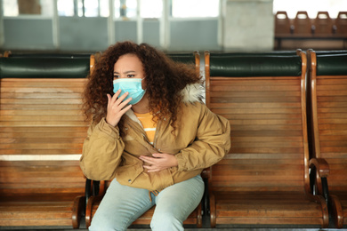 African-American woman with disposable mask indoors. Virus protection