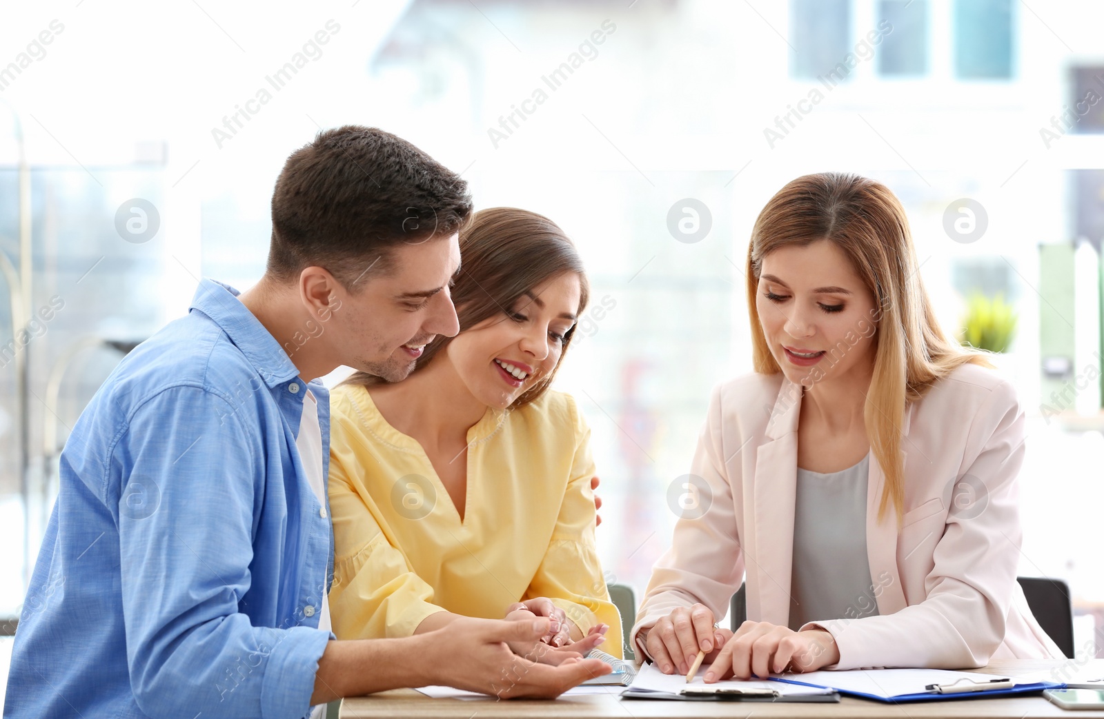 Photo of Young couple meeting with consultant in office