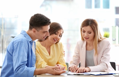 Photo of Young couple meeting with consultant in office