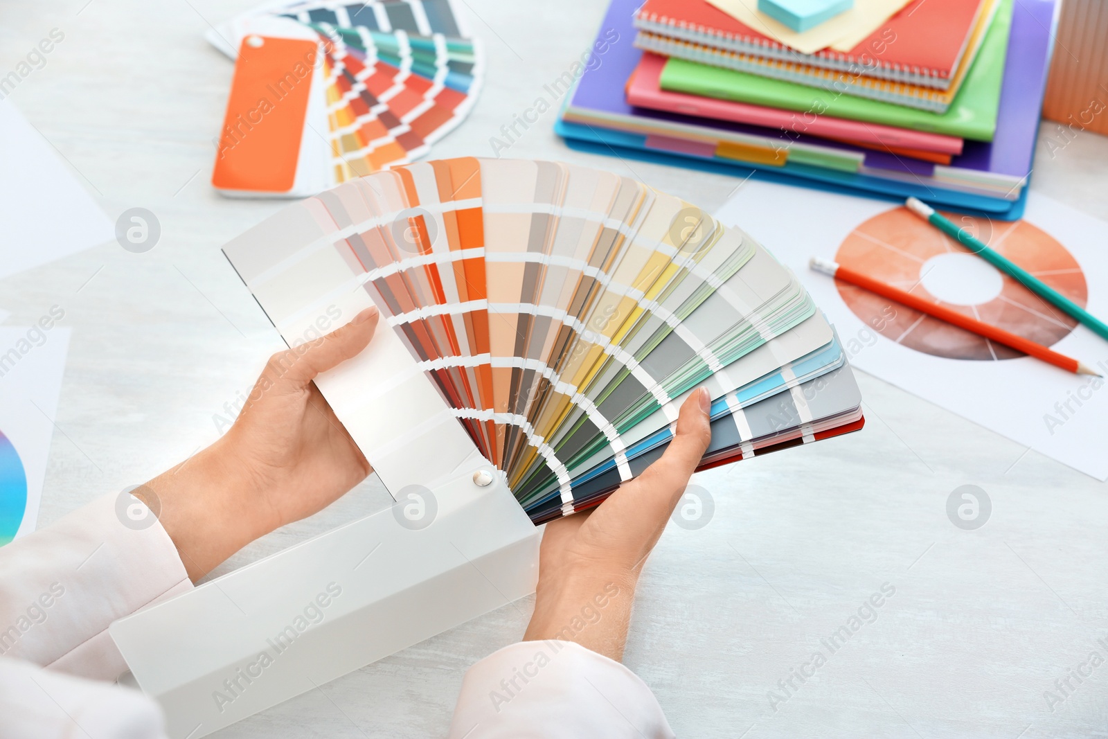 Photo of Woman with paint color palette samples at table, closeup