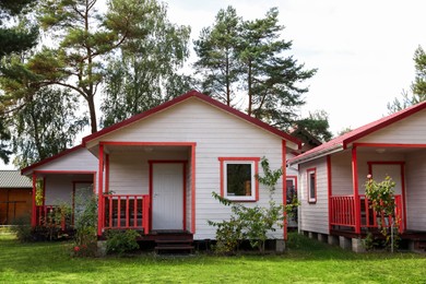 Photo of Beautiful modern white houses near trees outdoors