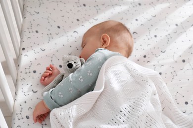 Photo of Adorable baby with toy peacefully sleeping in crib