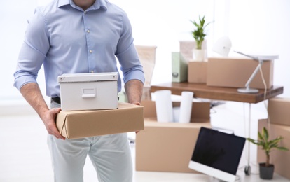 Photo of Man holding moving boxes in new office, closeup. Space for text