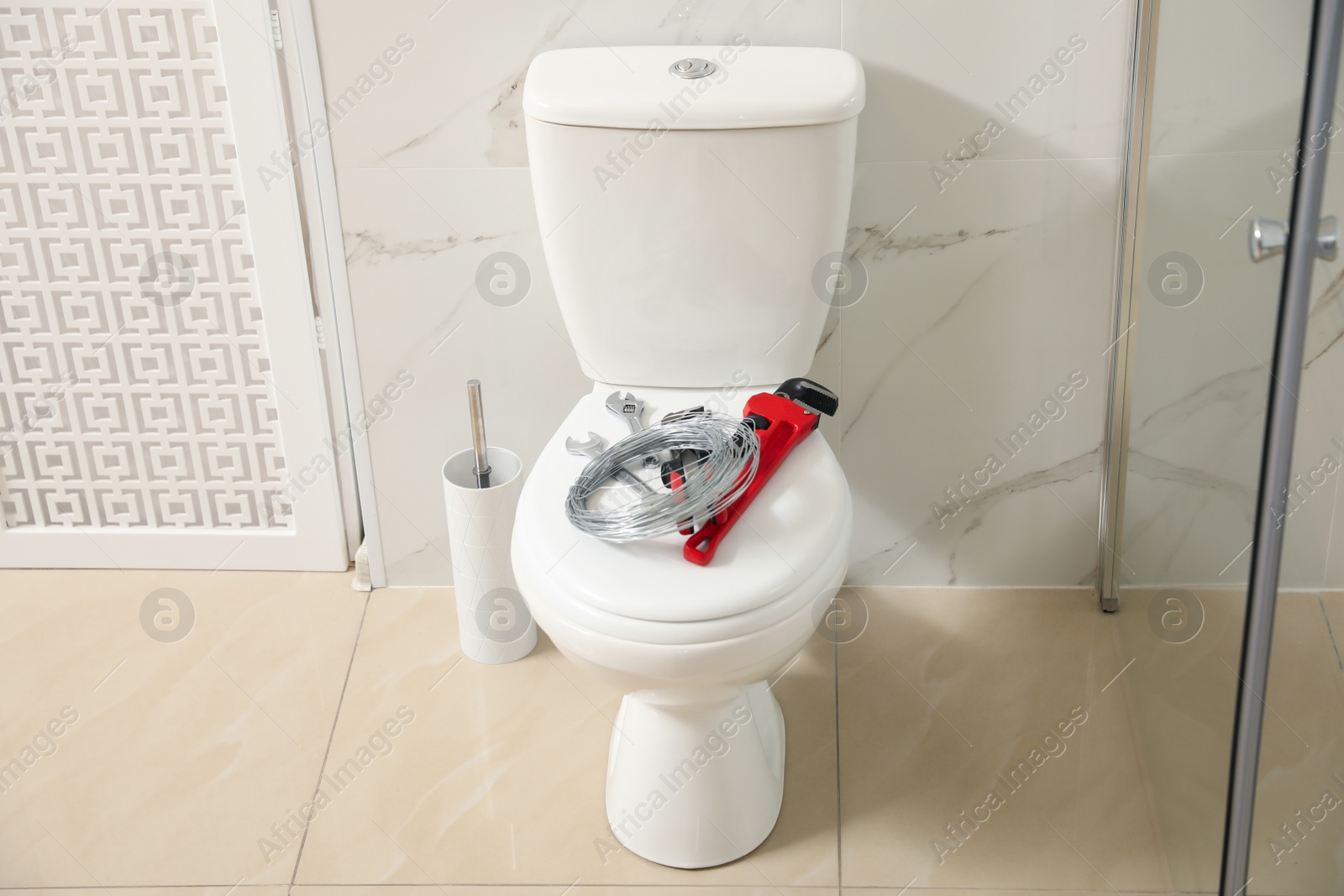 Photo of Plumber's tools on toilet bowl in bathroom