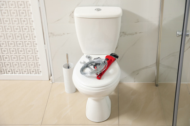 Plumber's tools on toilet bowl in bathroom