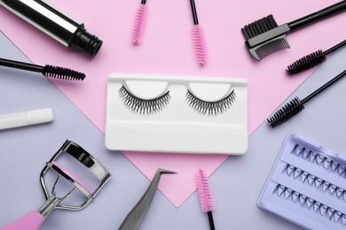 Flat lay composition with fake eyelashes, brushes and tools on color background