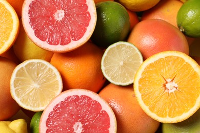 Different fresh citrus fruits as background, top view