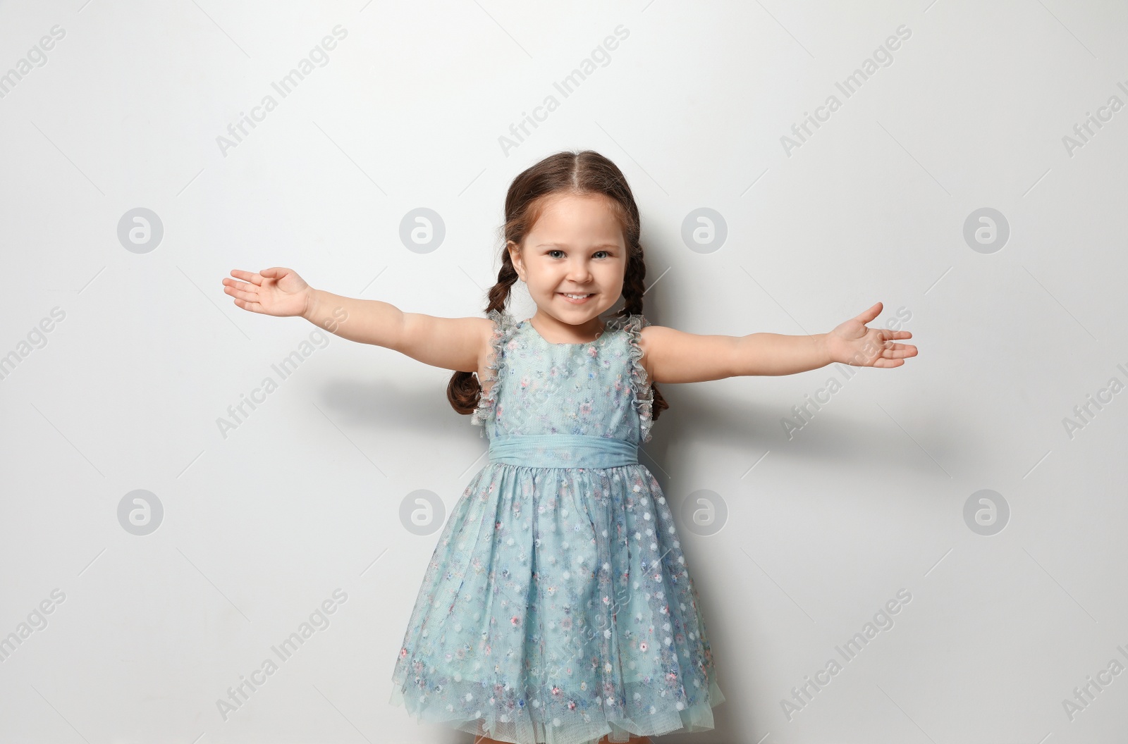 Photo of Cute little girl on light grey background