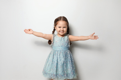 Cute little girl on light grey background