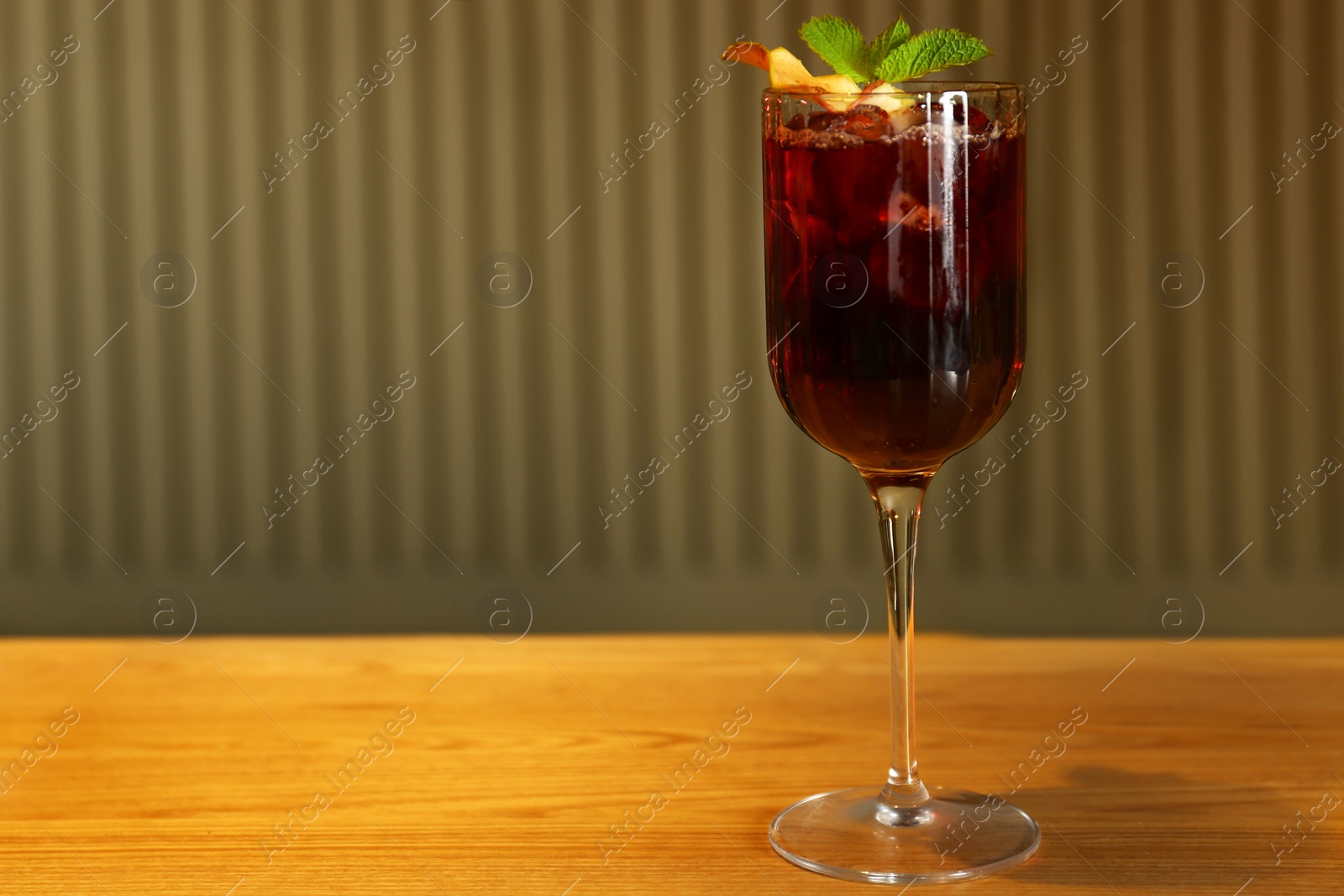 Photo of Glass of delicious cocktail with vodka on wooden counter in bar. Space for text