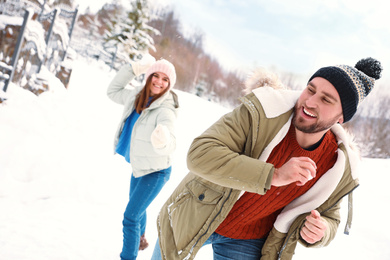 Photo of Happy couple playing snowballs outdoors. Winter vacation