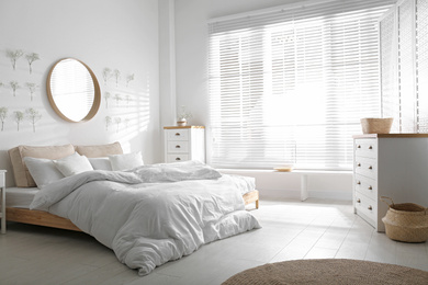 Photo of Stylish bedroom interior with white chest of drawers