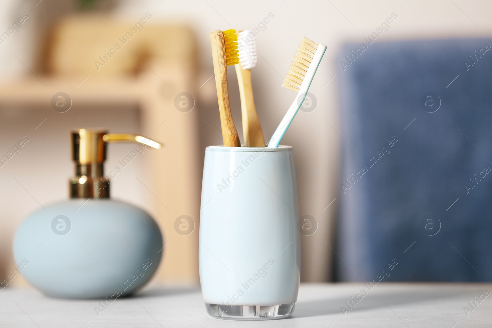 Photo of Bamboo toothbrushes in holder on light table indoors, closeup