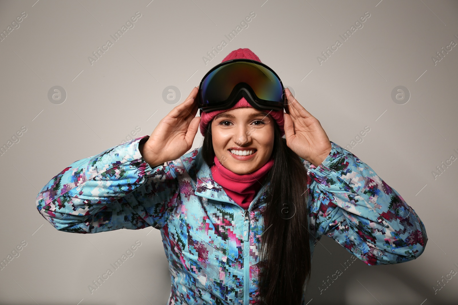 Photo of Woman wearing stylish winter sport clothes on light grey background